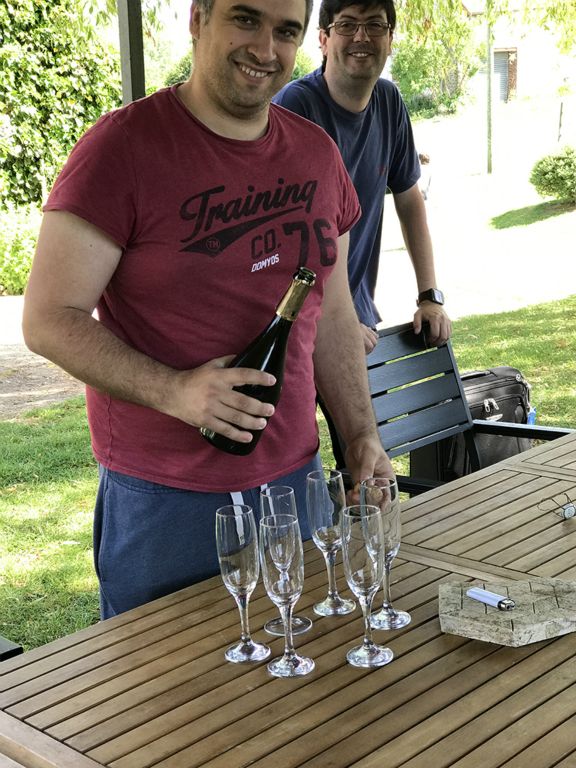Paul is ready to pour the champagne; Nicholas looks on